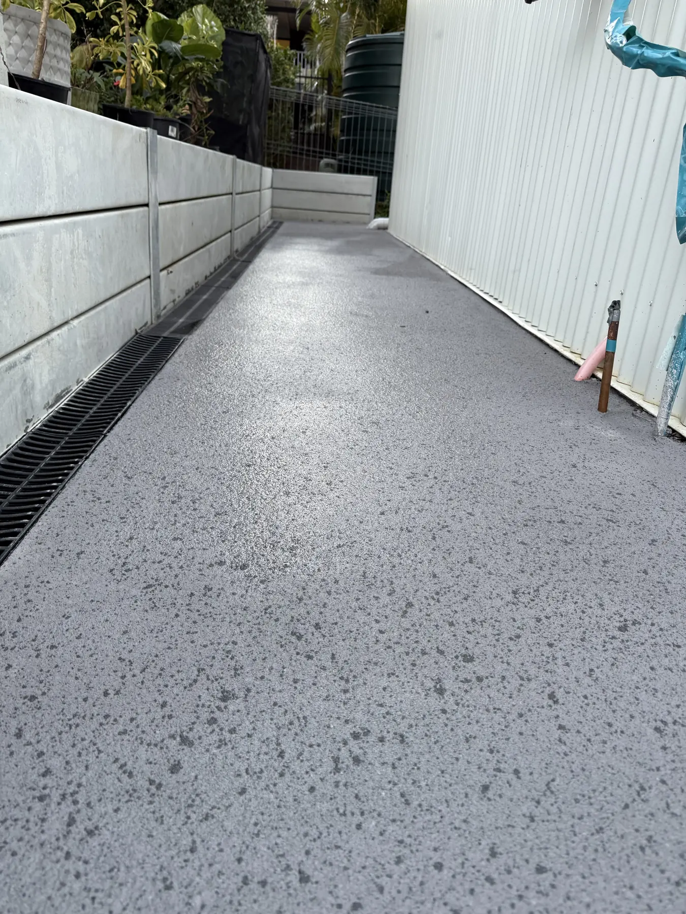 Exposed aggregate side path looking down the length of a house
