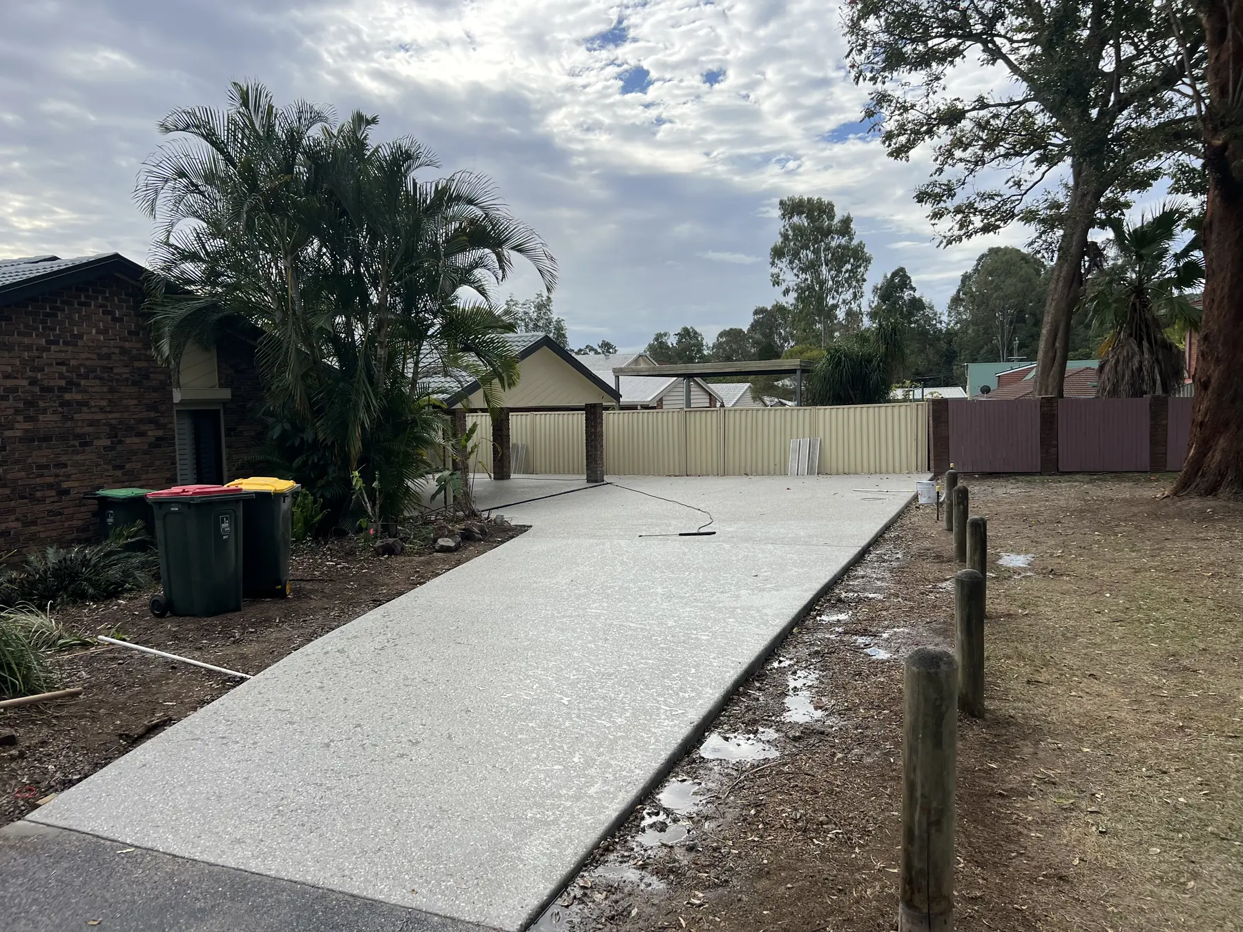 Long concrete driveway running down the side of a house to the back shed
