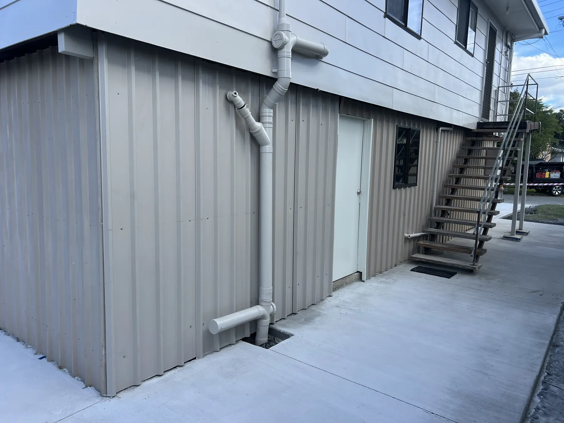Clean concrete path down the side of a house